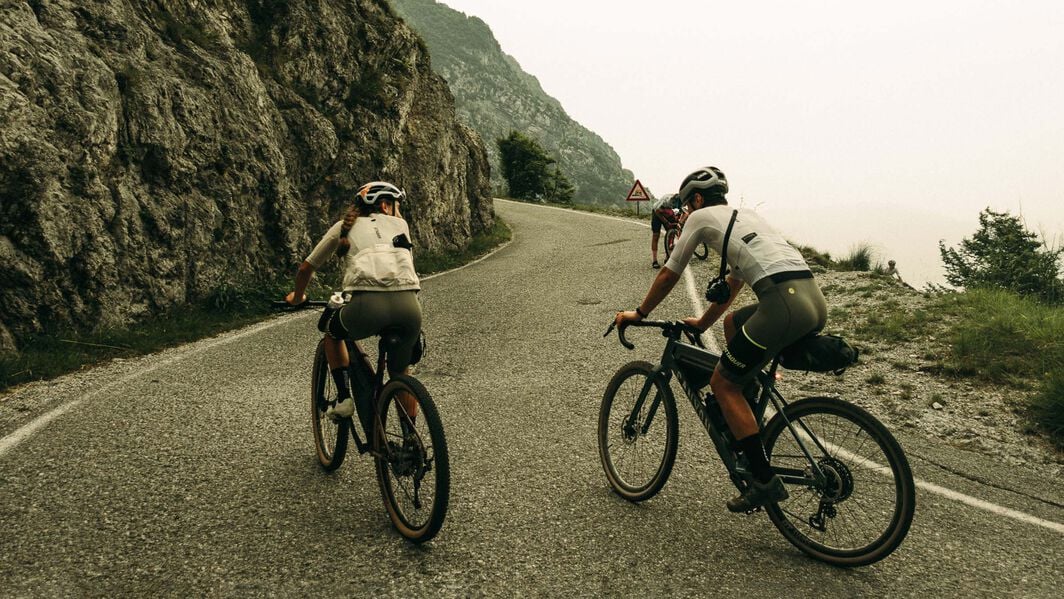 Lighting options for bikepacking bikes—riders tackle winding mountain roads with lights and gear ready for long-distance travel.